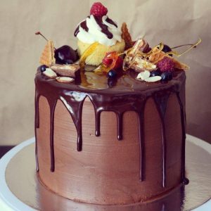 круглый шоколадный торт с фруктами и вафлями